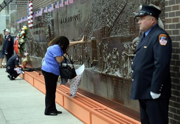 家屬在紐約市消防局的911紀念碑前緬懷救災中喪生的親友 (圖:AFP)