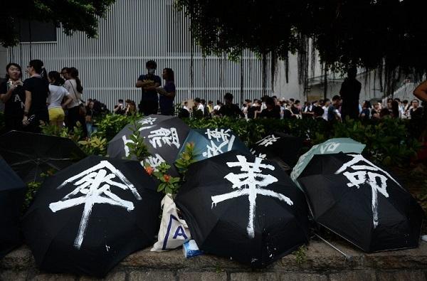 香港民眾嘗試以雨傘抵擋警方的催淚彈 (圖:AFP)