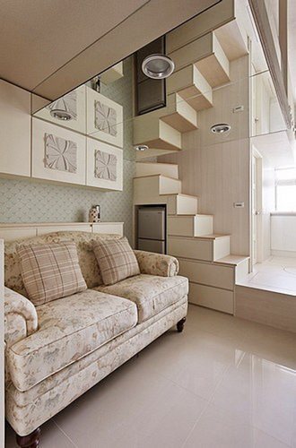 玄關望向室內局部鑲有玻璃鏡面地天花板，由下而上延伸出到樓梯線條，營造出室內挑高般地視覺享受。