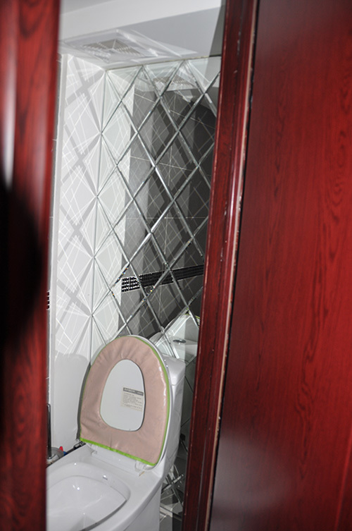 衛生間一角（馬桶上面的菱形鏡片據說是業主親手一張一張粘上去的。）