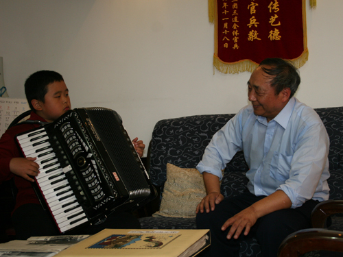 任士榮正在教兒童拉手風琴