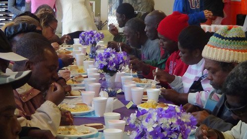 圖為無家可歸者在收容所中心用餐。