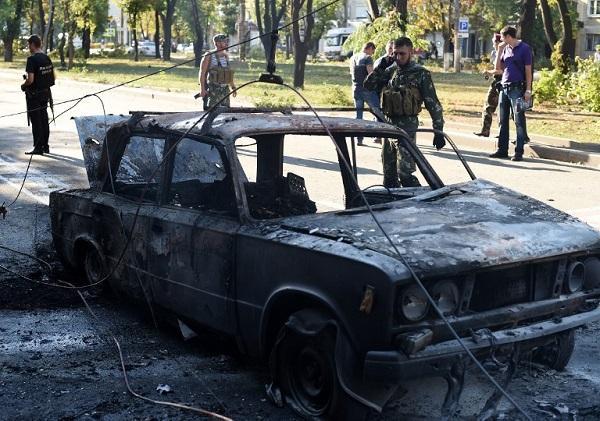 頓涅茨克(Donetsk)：親俄武裝份子清理頓涅茨克一輛毀壞汽車的附近區域，在一陣掃射中，有3人死於車內，並造成街面電車電纜線斷裂 (圖:AFP)