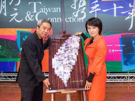 台灣大將樂迷珍貴的回憶照片，製成台灣地圖，由台灣大哥大基金會秘書長阮淑祥(右)送給胡乃元。(圖：台灣大提供)