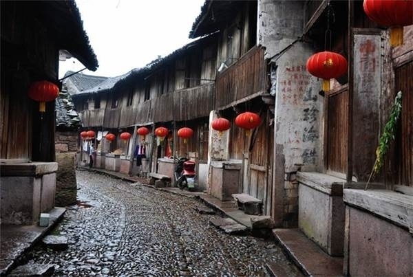 皤灘古鎮是一個商貿古鎮,源起唐宋,盛於明清。沿著一條小巷穿進古鎮,唐、宋、元、明、清、民國時遺留下來的民宅古居,呈現在你眼前,有些走進了武俠小說里的錯覺。形似一條祥龍的古街全部由鵝卵石鋪就,在陽光照耀下,好像閃閃發光的龍鱗。四周商鋪的旗號還在,門板卻緊緊關上,好像有什么江湖大事要發生似的。