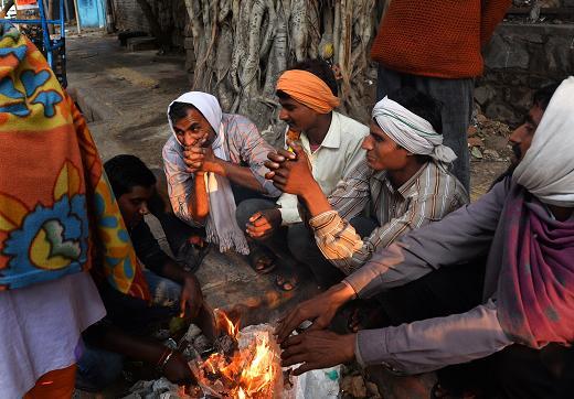 印度新德里人力車司機在路邊生火(圖：AFP)