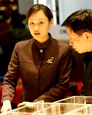 一小時后，客戶離開，薛梅的腳已經紅腫。小區剛開盤時，每天要接待上百位客戶，每天早上8時開門時，已有許多客戶排隊等候。晚上12時，還有人拿著合同等著辦手續。