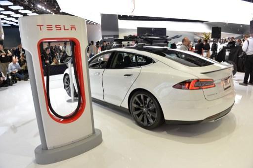 於今年1月美國底特律車展，展出的特斯拉電動車與充電站。(圖:AFP)