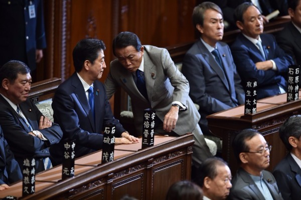 安倍與財相麻生太郎等官員多次會談，決定延遲加稅。  (圖：AFP)