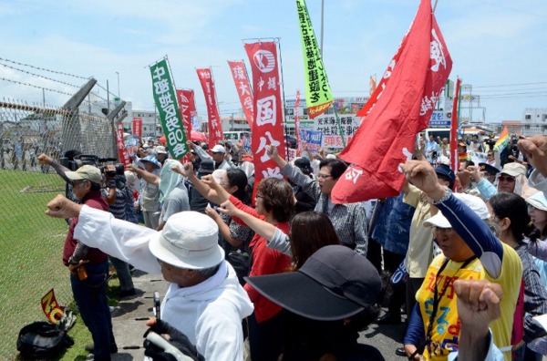 沖繩居民高舉拳頭，抗議美國嘉手納空軍基地美兵姦殺20歲的女子島袋里奈。  (圖：AFP)