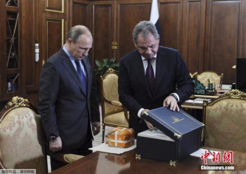 俄防長向普欽展示戰機黑匣子。  圖片來源：中新網