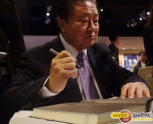 台達電董事長鄭崇華為新書「實在的力量」簽名。(鉅亨網記者王定傳攝)