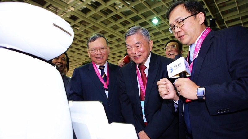 中華電董事長鄭優(左)經濟部次長沈營津(中)與迎賓機器人互動。(圖：中華電提供)