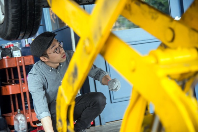 張博智用千斤頂抬起客人的汽車，看起來又man又帥氣。