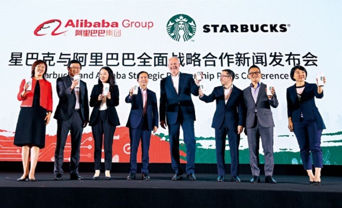 不敵新零售風潮，星巴克執行長強森(右4)與阿里巴巴首席執行長張勇(左4)攜手外送服務。強森說，「中國是星巴克發展和創新速度最快市場。」(來源．法新社)