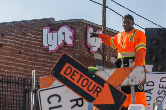 Lyft 創始人 Logan Green 和 John Zimme 以及其他公司高管,在距離納斯達克數千英里之外的洛杉磯一家前汽車經銷商處按鈕宣告上市掛牌交易。(圖:AFP)