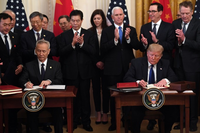 美國總統川普與中國國務院副總理劉鶴代表簽署第一階段協議。(圖片：AFP)