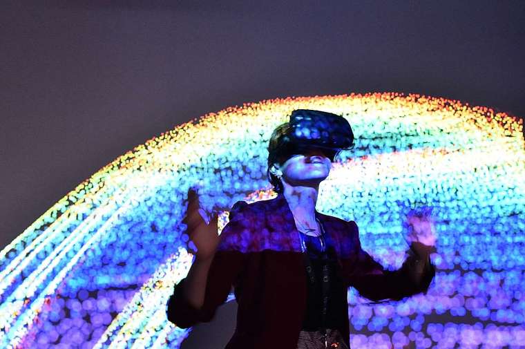 「元宇宙」的理論是任何人透過戴上 AR/VR 等穿戴裝置，進入「加強版」的虛擬世界 (圖片：AFP)