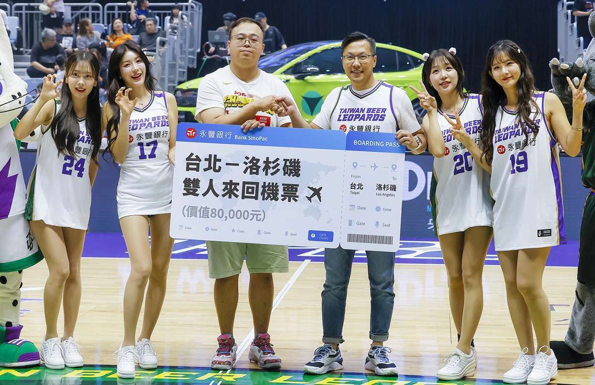 幸運球迷(左三)於20日「國際日」挑戰中線投籃,展現神射美技,一球命中;永豐銀行大方贈出價值新台幣8萬元的台北—洛杉磯雙人來回機票,由永豐銀行資深副總經理徐德里(右三)代表頒獎。