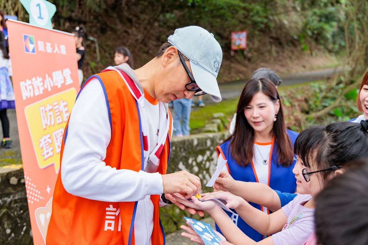 防詐小學堂設計了生動有趣的闖關遊戲,王銘陽董事長(左一)擔任關主,孩子們要知道正確防詐知識,還得手腳並用才能成功過關,在寓教於樂中建立觀念。(圖:凱壽提供)