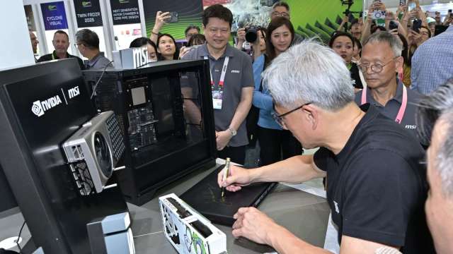 黃仁勳參訪微星現場簽名AI超級電腦展 讚揚產品開發速度。(圖:微星提供)